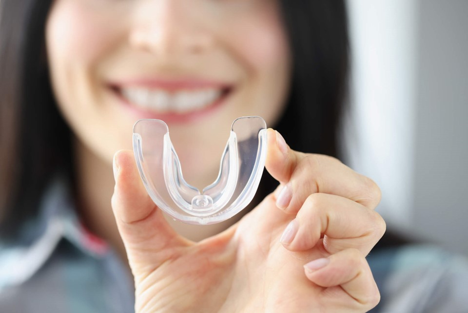 A person holding a clear mouthguard