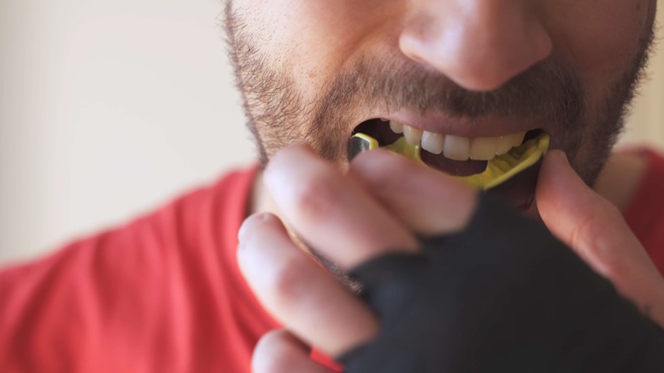 A close-up of a person putting in a mouthguard