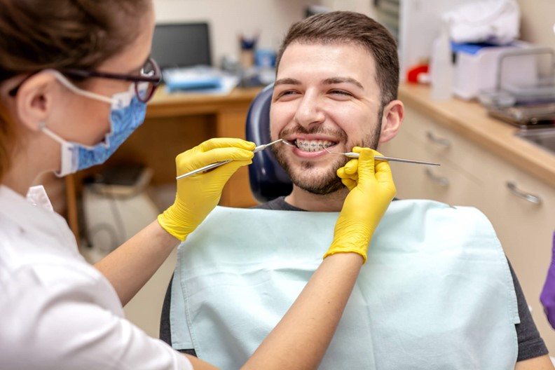A Dentist in Scottsdale, AZ, is Examining a Person's Teeth.
