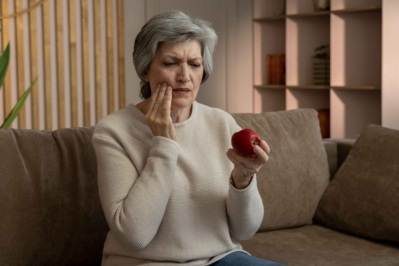 A Person in Scottsdale, AZ, Holding an Apple and Experiencing Tooth Pain.

