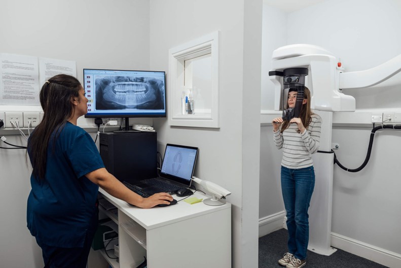 An Xray technician performing dental imaging